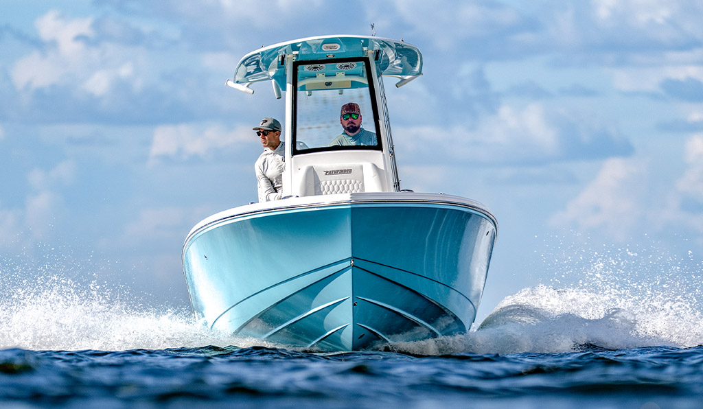 Low-angle, water-level view of a Pathfinder 2400 Hybrid running head-on toward the camera, bow spray visible on each side.