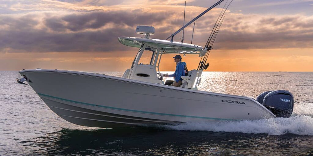 Cobia 265 Center Console with outriggers and Yamaha Twin Engines running at sun rise.